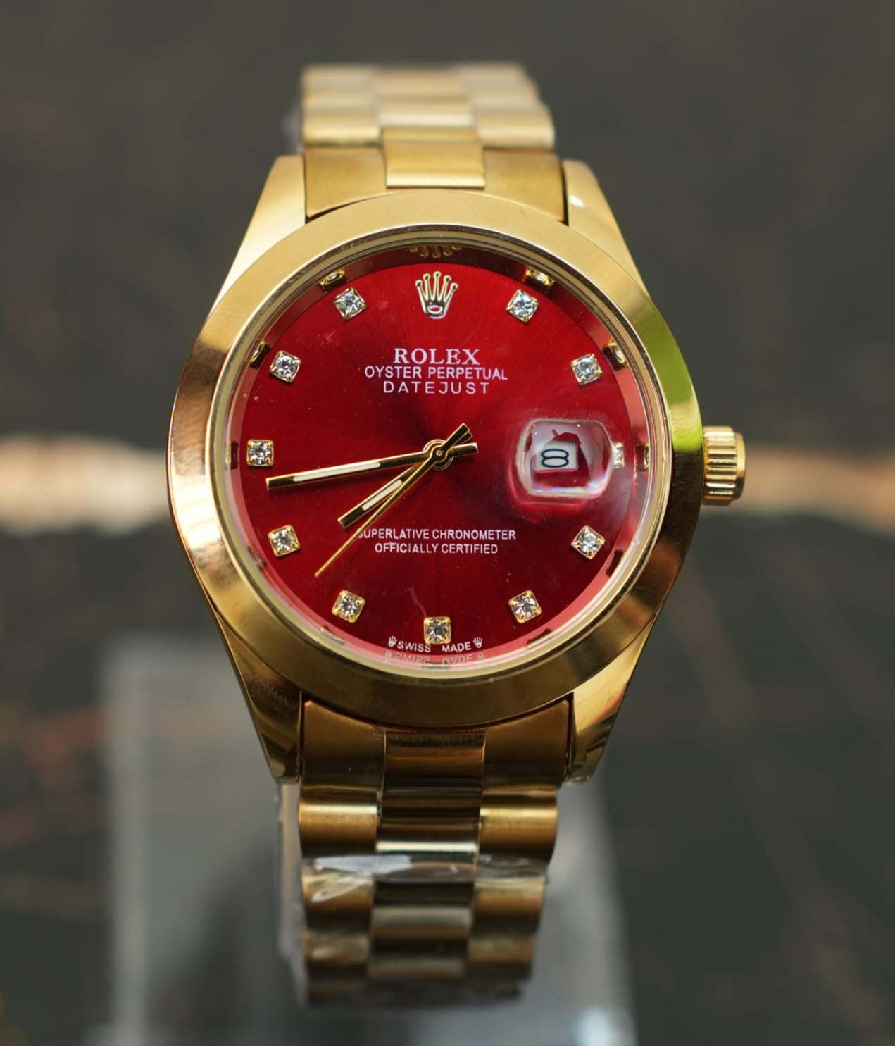 Gold rolex watch with a red dial