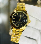 Gold rolex wristwatch with black dial held by a white gloved hand